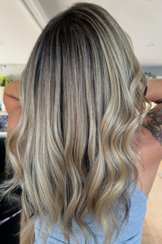 Dark hair with warm blonde highlights to blend gray for a soft, glowing look.