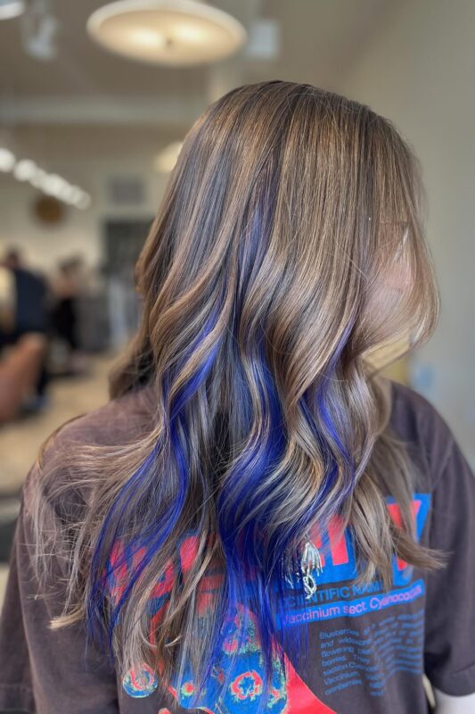 Woman with blue peekaboo highlights.