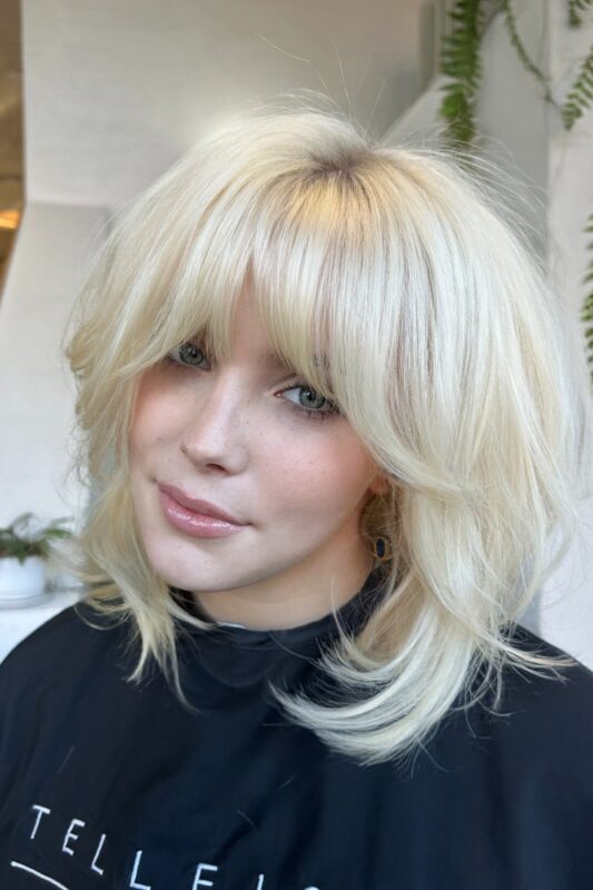 Woman with a bob haircut and face-framing layers.