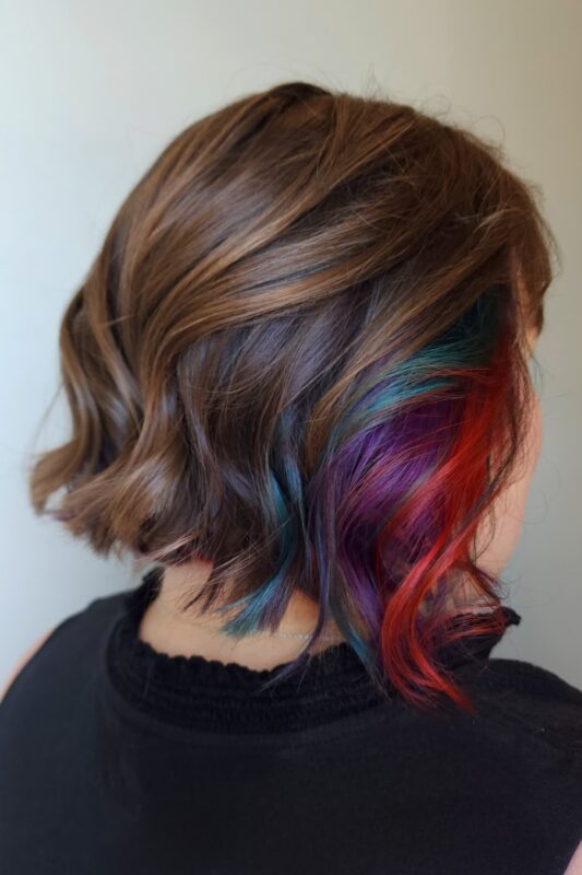 Woman with brown hair featuring peekaboo highlights.