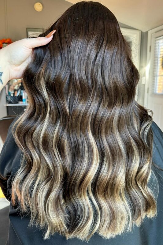 Woman with brown hair featuring blonde peekaboo highlights.