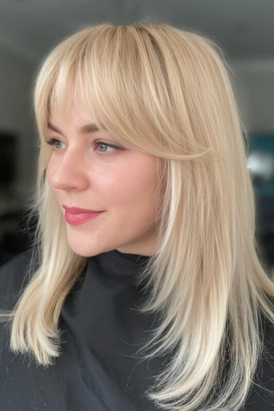 Woman with face-framing layers paired with bangs.