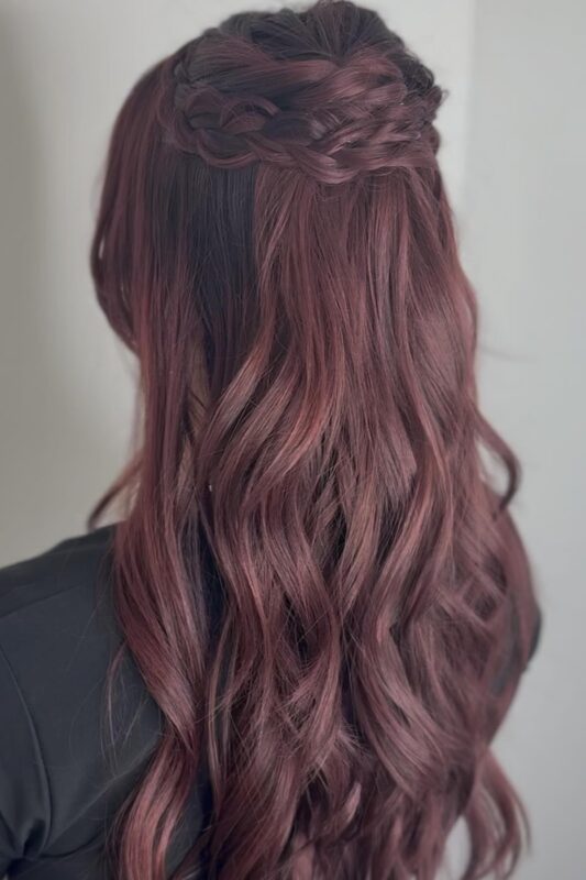 Woman with a half-up, half-down braided crown Christmas hairstyle.