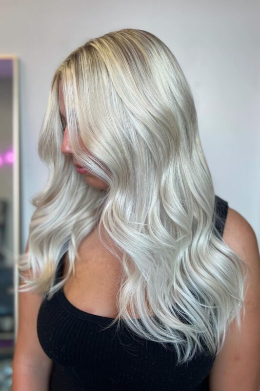 Woman with icy platinum blonde hair and a shadow root.