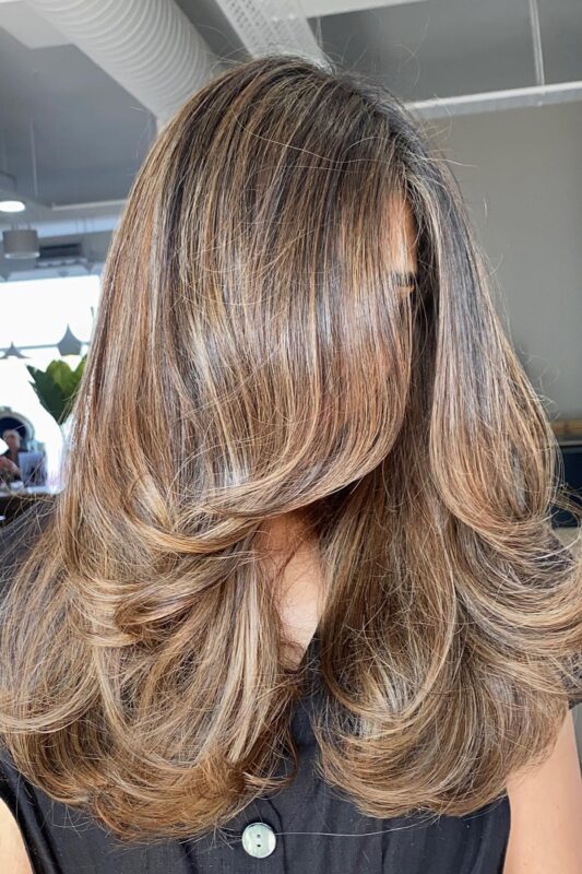 Woman with a long butterfly layers haircut.