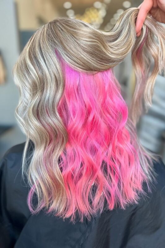 Woman with peekaboo pink highlights.