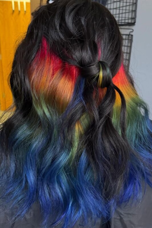 Woman with a peekaboo rainbow hair color.