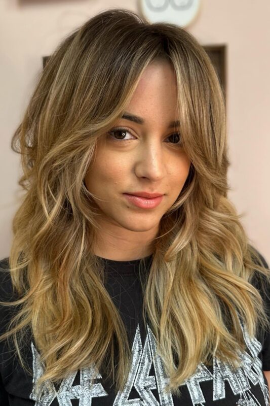 Woman with a wispy face-framing layers haircut.