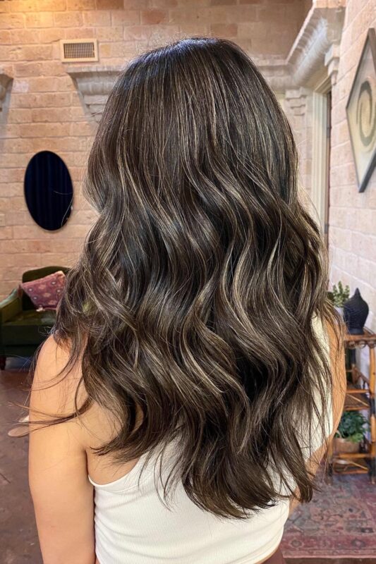 Brunette hair with honey-toned highlights for blending first grays.