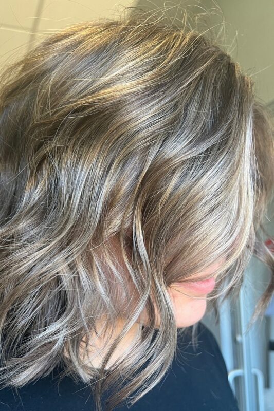 Brown hair with cool-toned blonde highlights to blend grays.