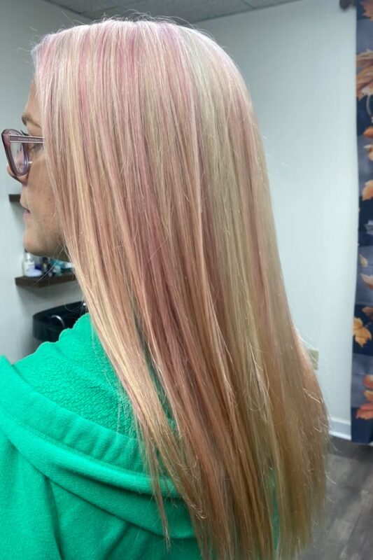 Woman with blonde hair and light pink highlights.