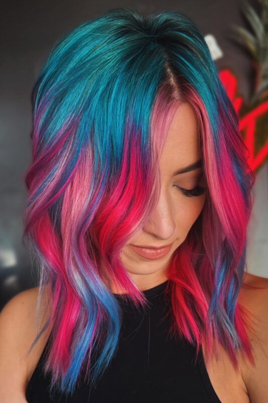 Woman with blue and pink highlights in a color melt style.