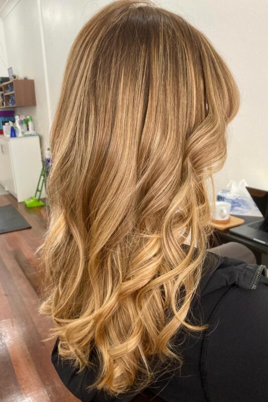 Woman with a caramel blonde balayage.