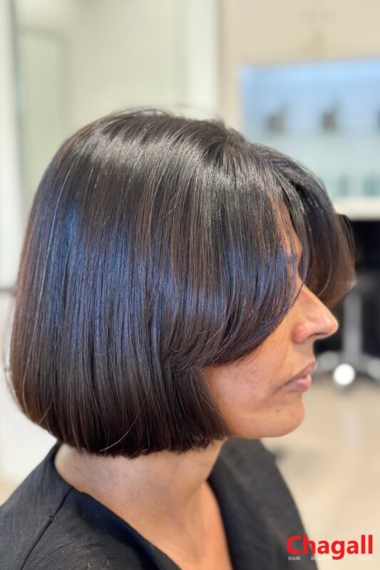 Woman with a chin-length 90s bob haircut.