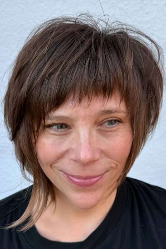 Woman with a chin-length shaggy bob haircut.