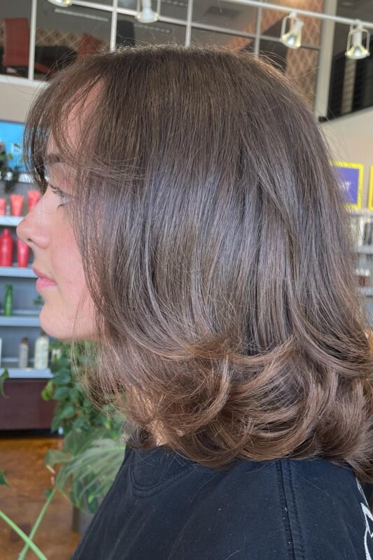 Woman with a layered bob haircut with bangs for fine hair.