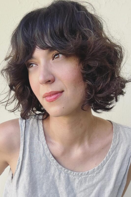 Woman with a French bob haircut on curly hair.