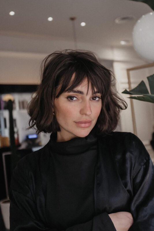 Woman with a French bob haircut featuring bangs.