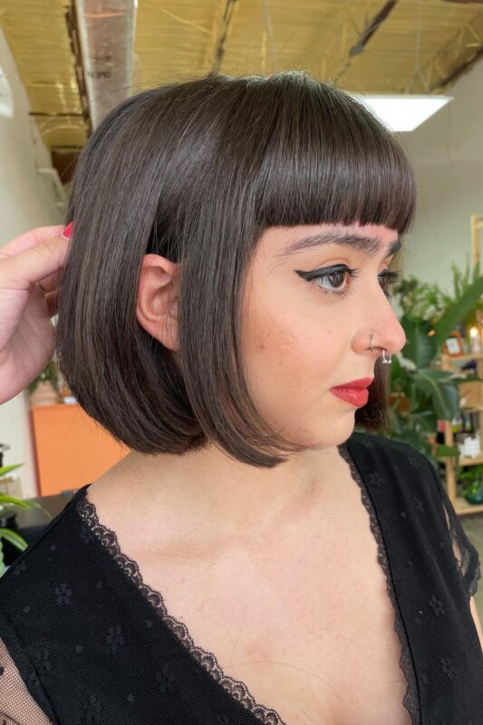 Woman with a French bob featuring Bettie bangs.