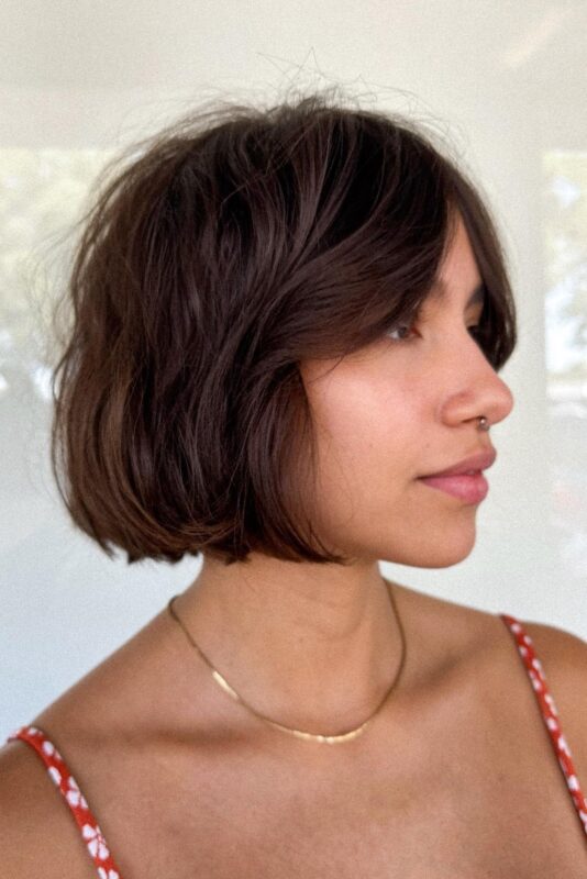 Woman with a French bob haircut featuring curtain bangs.