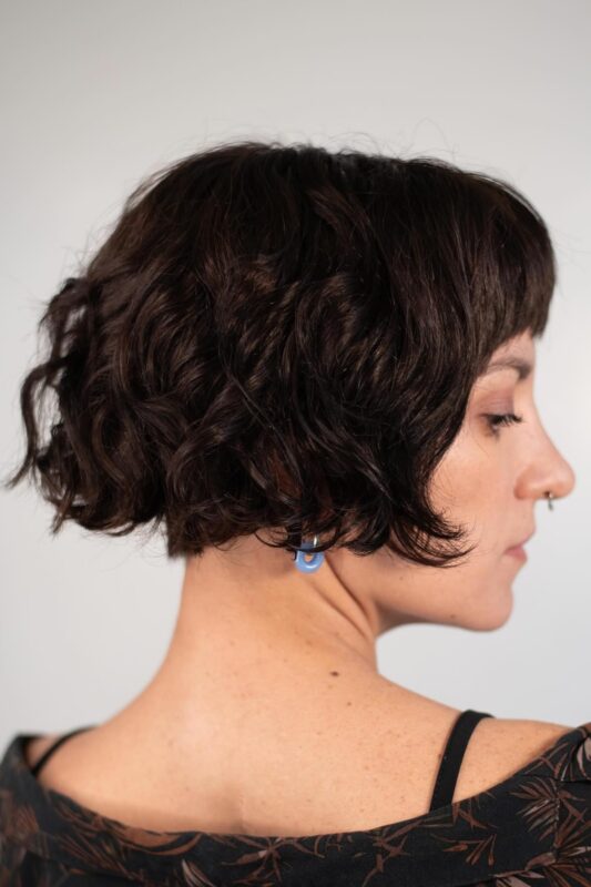 Woman with a French bob haircut and micro bangs.