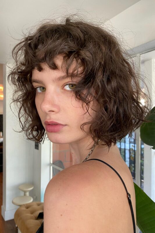 Woman with a French curly bob hairstyle.