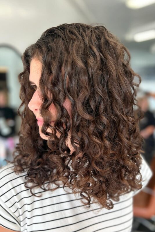 Woman with a haircut tailored for curly fine hair.