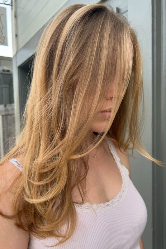 Woman with a long layered haircut suitable for fine hair.