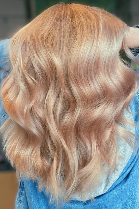 Woman with a peachy rose gold hair color.