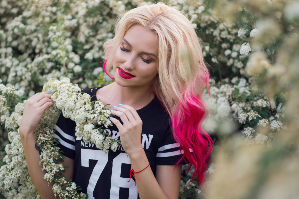 Woman with pink highlights in her blonde hair.