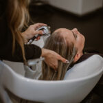 Woman in a hair salon getting treatment for gray blended hair.