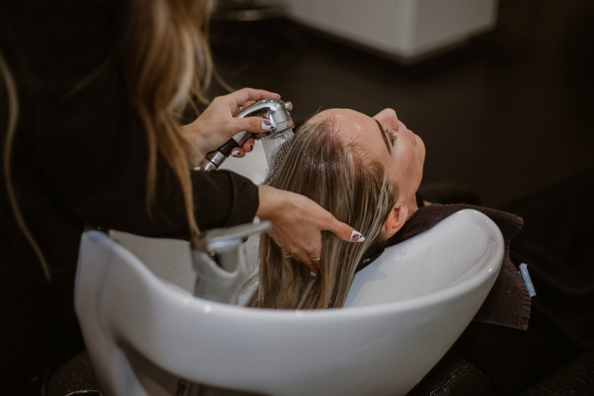 Woman in a hair salon getting treatment for gray blended hair.